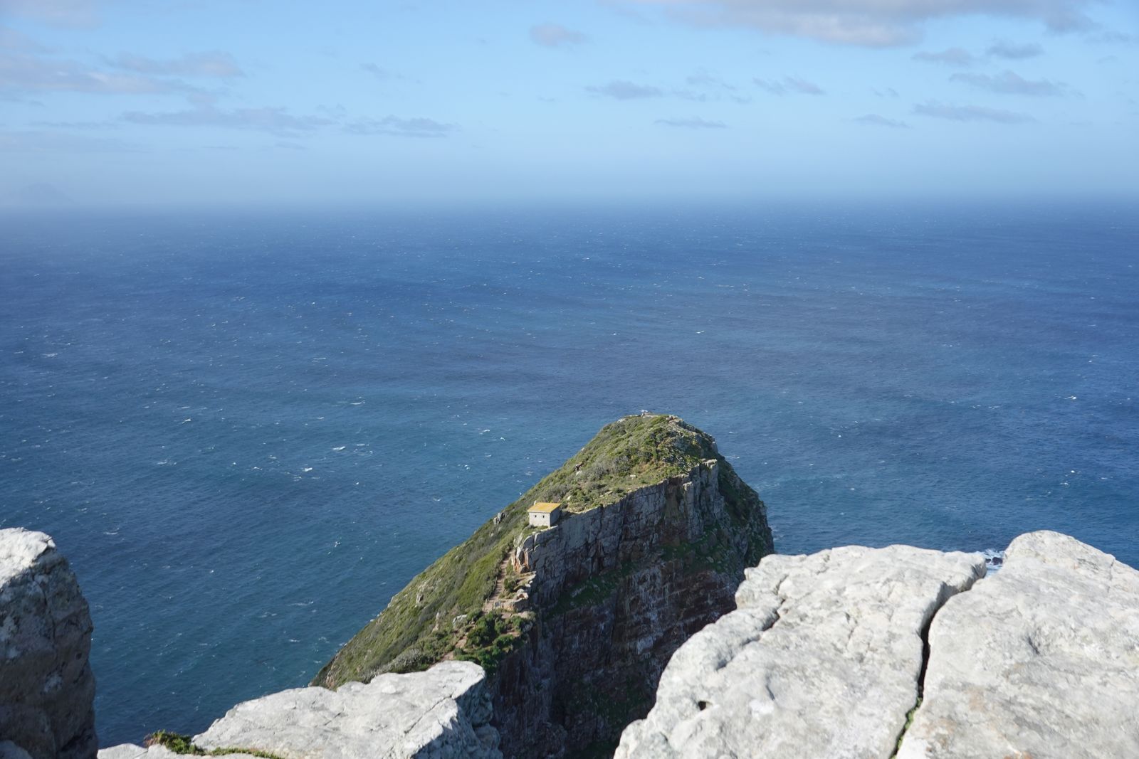 Rocky cliff dropping into deep blue ocean