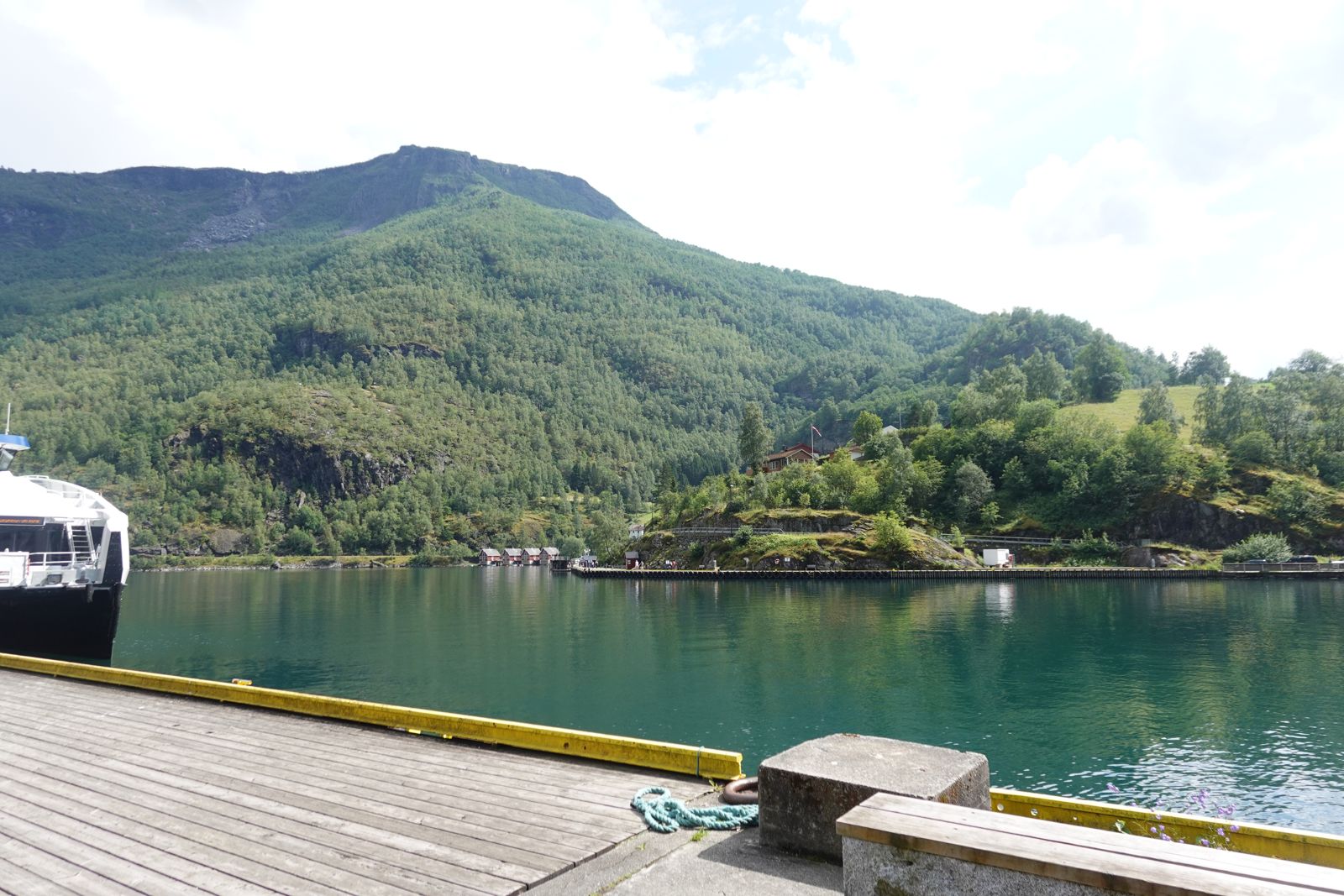 Green mountains over a still turquoise fjord
