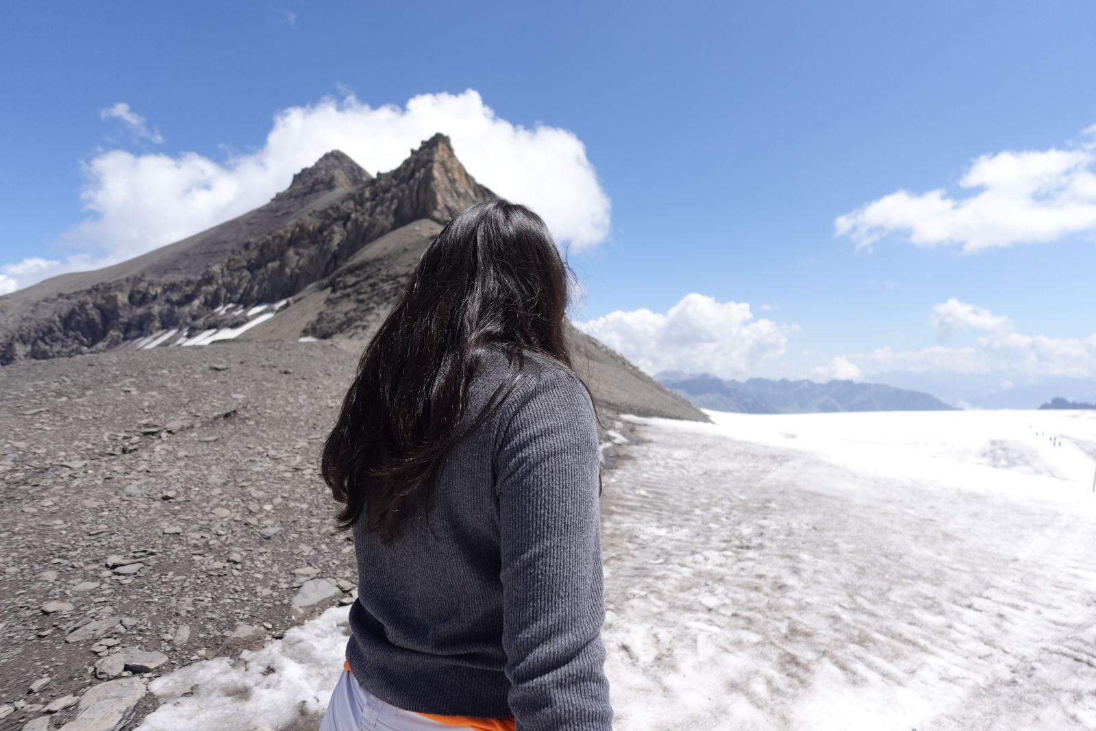 Me standing on a glacier below a rocky peak