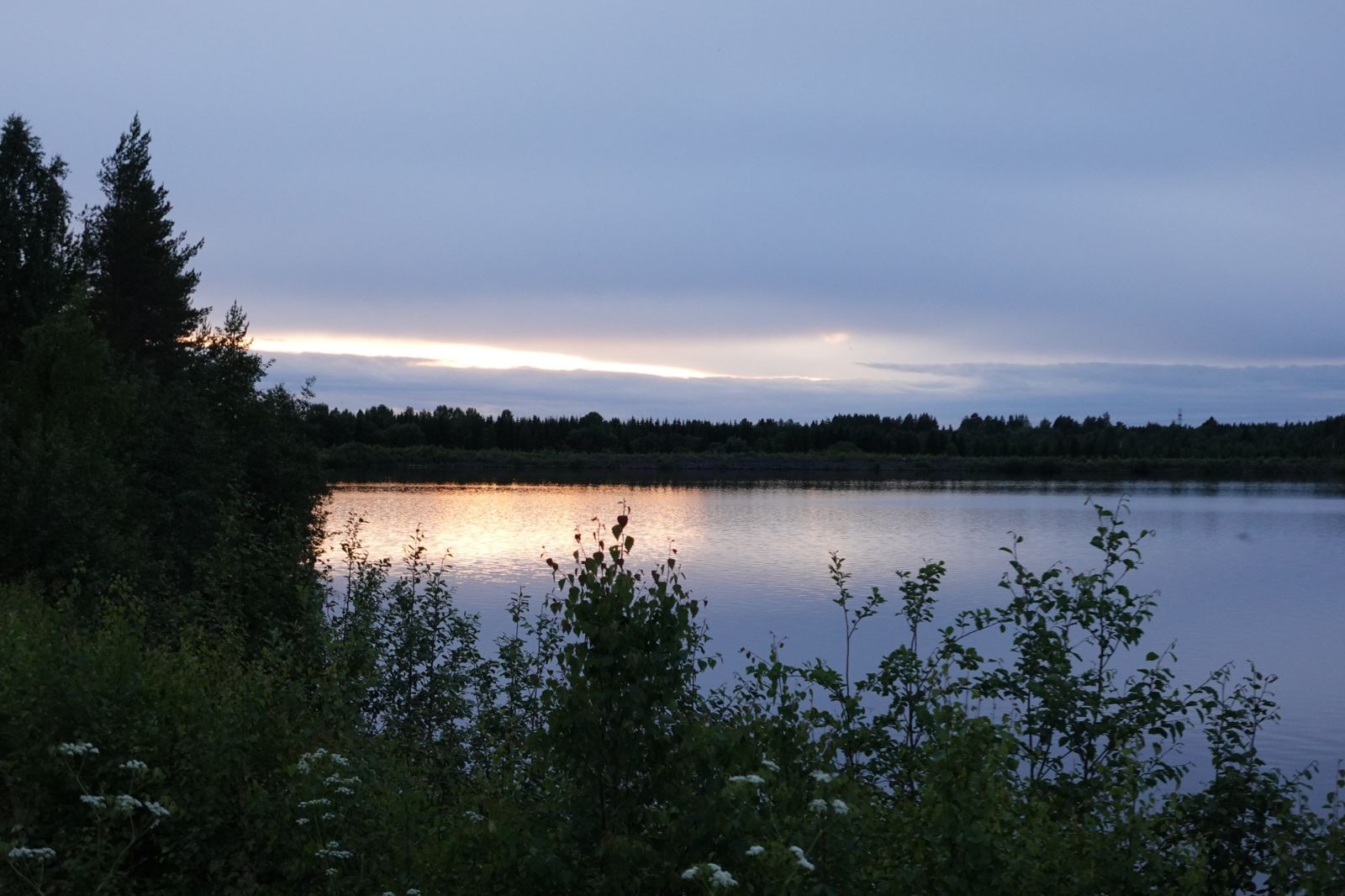 Lake at midnight under a thin band of light, Finland